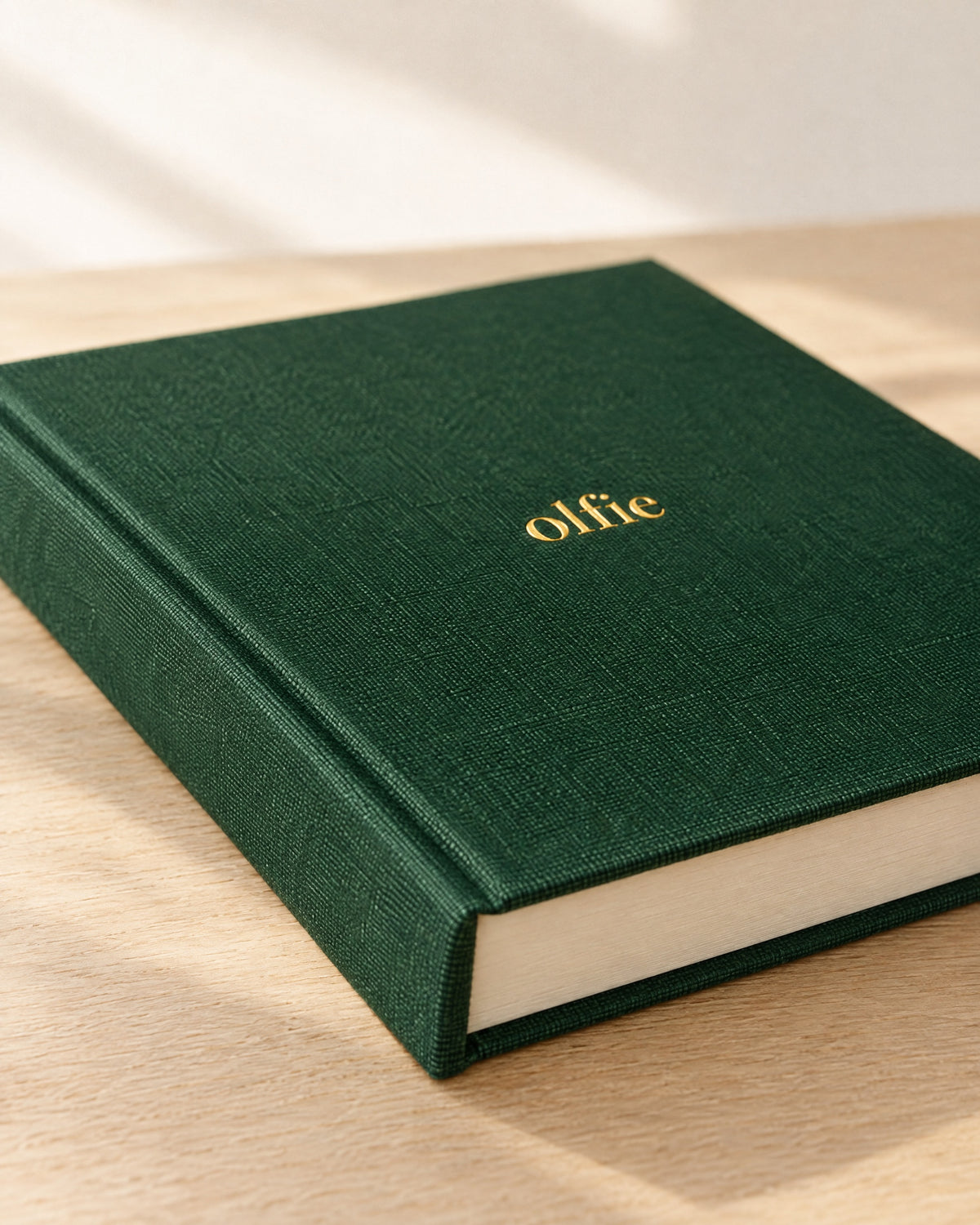 Close up of the forest green cloth and gold foil on The Olfie Book
